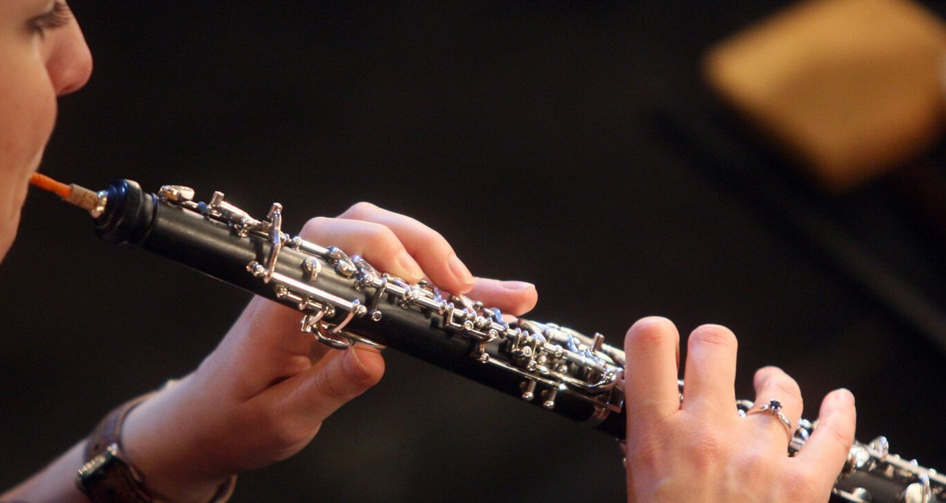 Eine Frau spielt Oboe, man sieht hauptsächlich die Hände. 